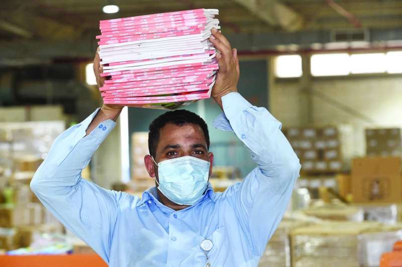 عامل في مخازن «التربية» يرفع كراسات أنشطة