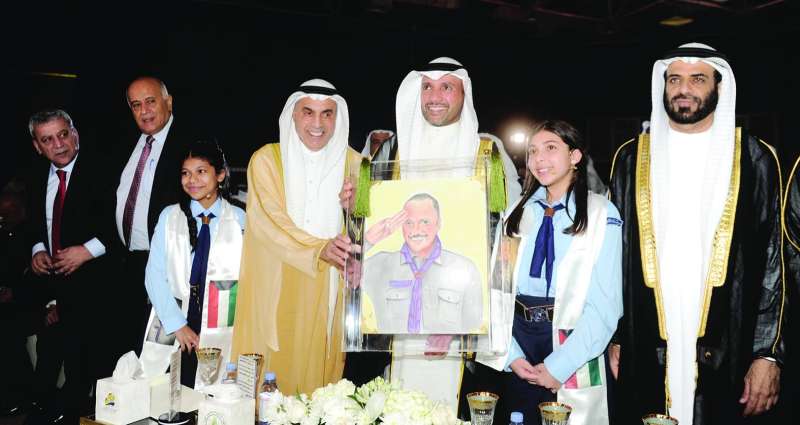 الغانم متسلماً من الطريجي لوحة تذكارية تحمل صورته بالزي الكشفي	 (تصوير سعود سالم) 