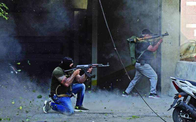 مسلحان يطلقان النار خلال الاشتباكات في منطقة الطيونة (ا ف ب)