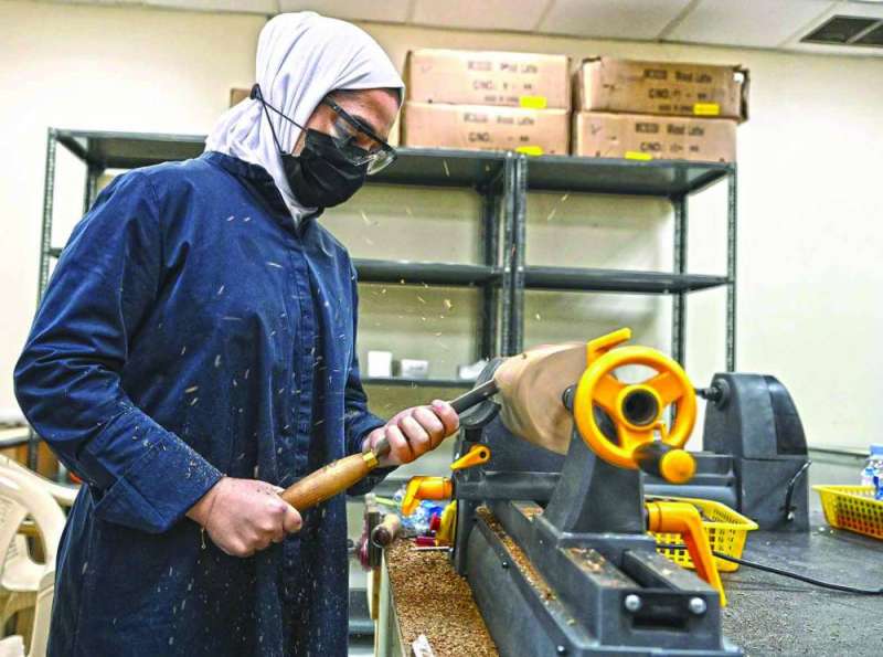 مُتدرّبة تقوم بنشارة الخشب
