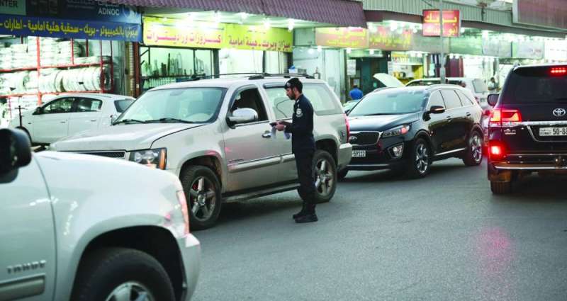 تدقيق على بيانات السيارات في أحد شوارع صناعية الجهراء (تصوير نايف العقلة)