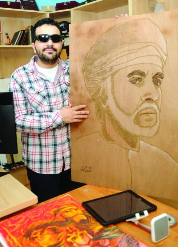 
الحمود مع لوحة لسلطان عمان الراحل قابوس
