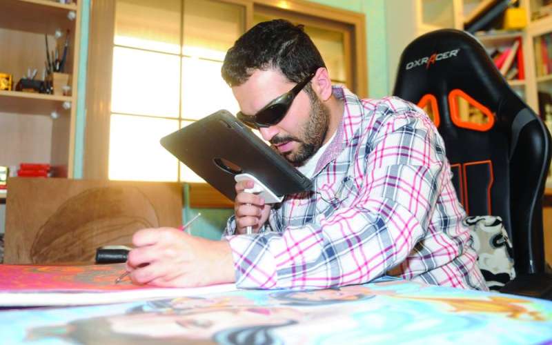 الحمود يستخدم جهازاً لتقريب الصورة أثناء رسمها