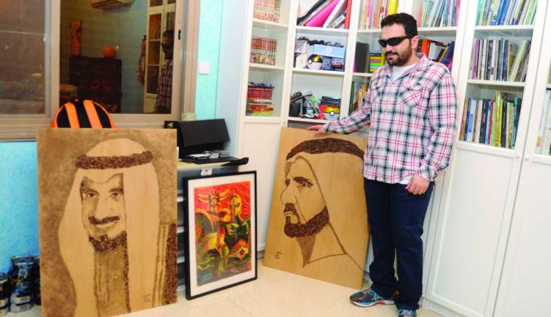 
الحمود أمام لوحتين للأمير الراحل الشيخ جابر الأحمد والشيخ محمد بن راشد آل مكتوم	 (تصوير سعود سالم)
