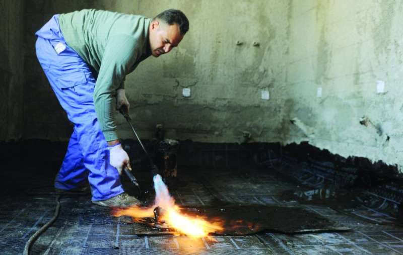 
عامل يقوم بتثبيت العازل بالنار	 (تصوير سعود سالم)
