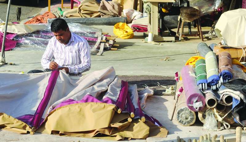 عامل يُجهّز إحدى الخيام في السوق