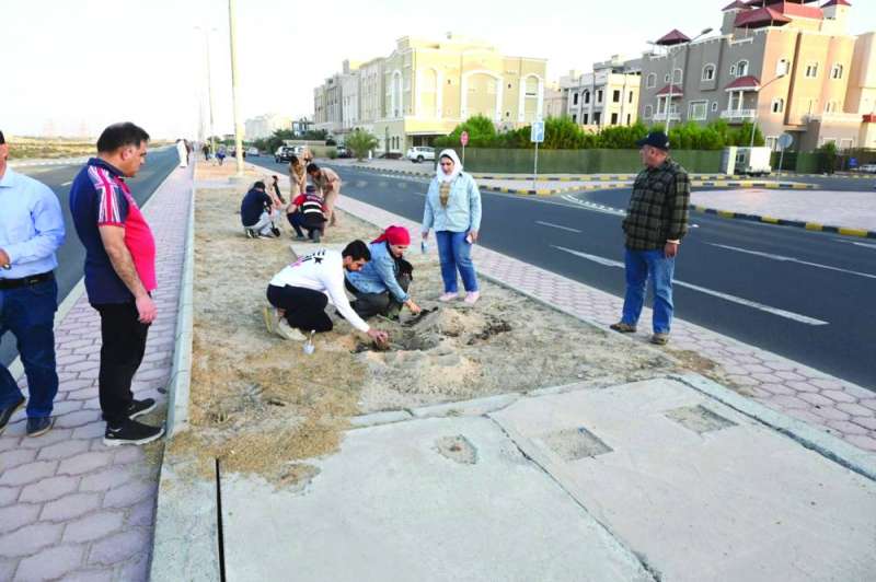 متطوعون وأهالٍ يشاركون في عملية التشجير 	
