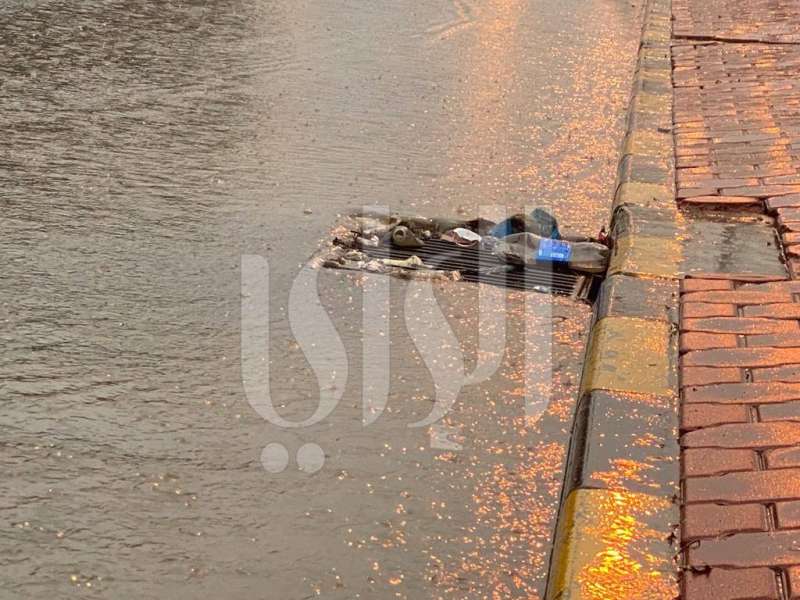 تراكم أوساخ حول إحدى فتحات المناهيل يبطئ تصريف مياه الأمطار 