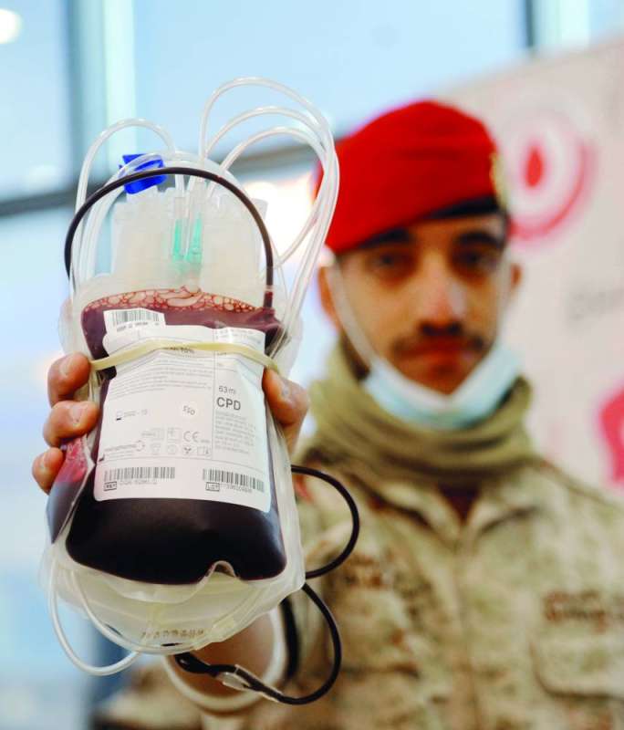 أحد المتبرعين يعرض كيس دماء عقب تبرعه