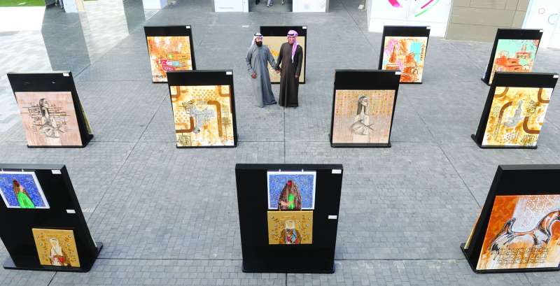 محسن الشمري يتوسط لوحاته مع الزميل علي شويطر
