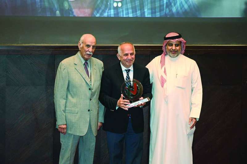 
الزميل علي بلوط خلال تكريمه متوسطاً السنعوسي والخميس
