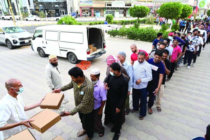 
جانب من توزيع وجبات الإفطار المغلفة على العمالة الوافدة 	 (تصوير أسعد عبدالله)