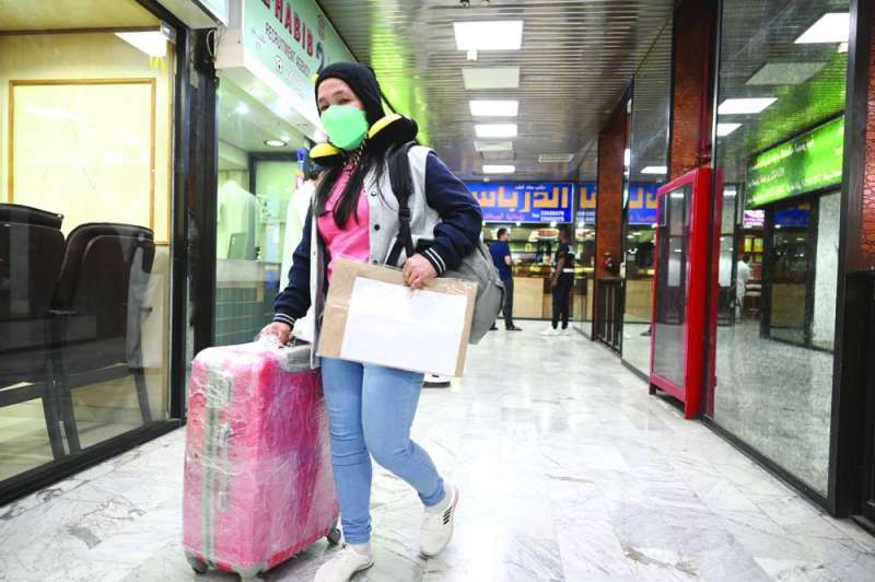 عاملة منزلية تحمل أوراقها ومتاعها