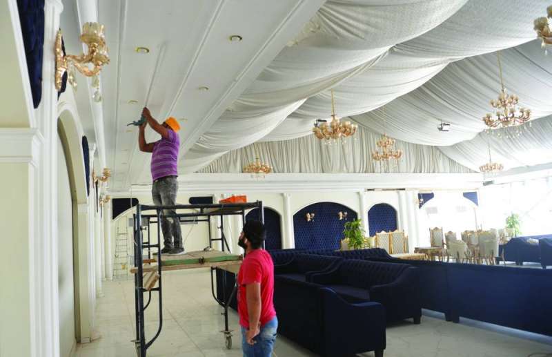 
عاملان خلال تجهيز إحدى الصالات