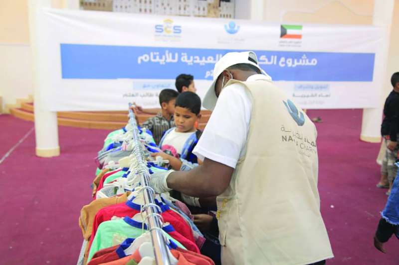 توزيع الملابس الجديدة على عدد من الصبية