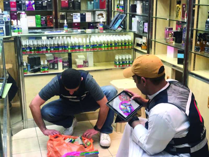 مفتشا التجارة يفحصان بعض المواد المتعلقة بصناعة العطور
