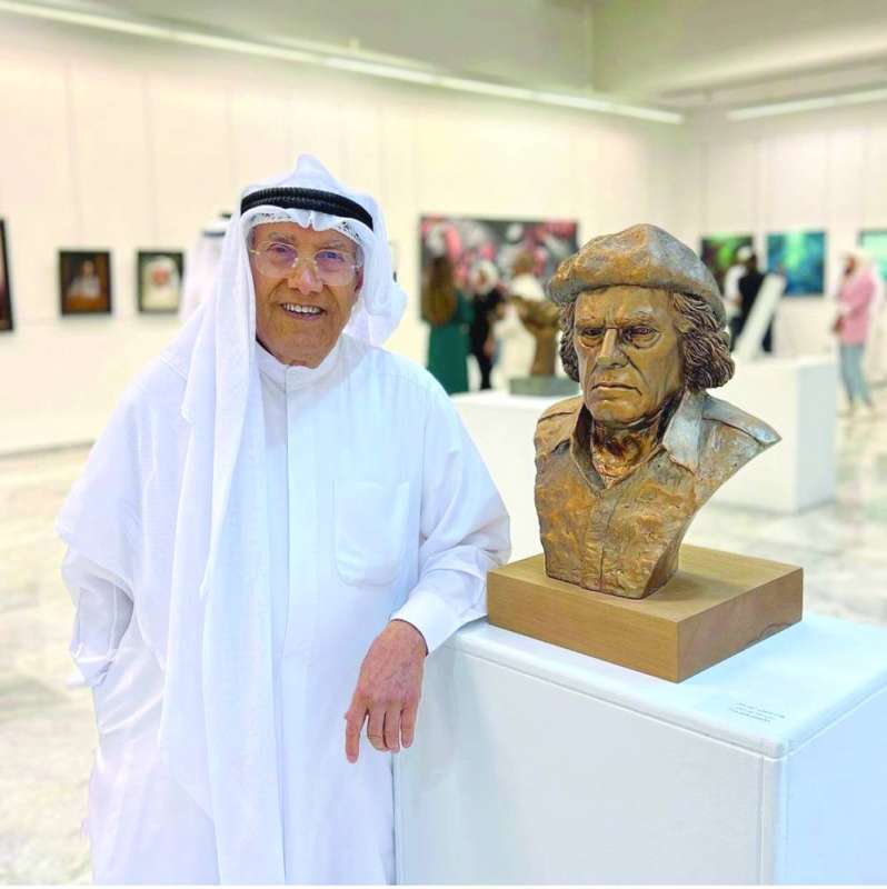 
سامي محمد إلى جانب المنحوتة الخاصة به
