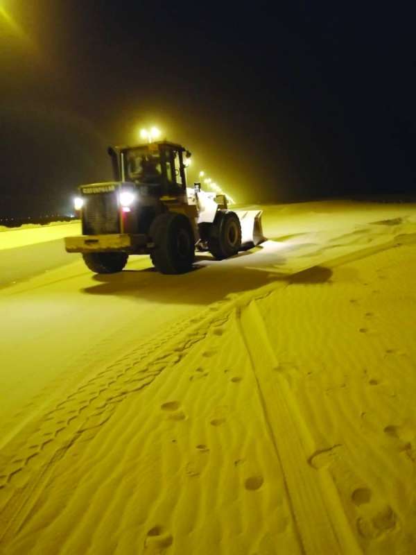 جرّافة ترفع الرمال المتراكمة