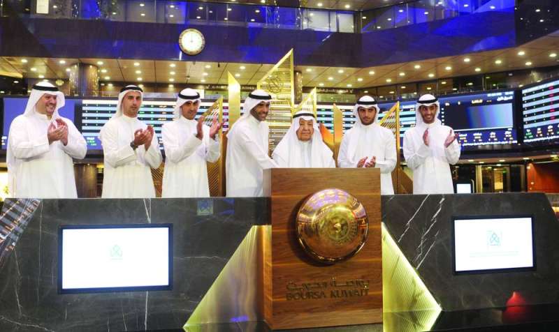 العم علي الغانم يقرع جرس التداول وبجواره فهد الغانم وبدر الخرافي وخالد الفلاح ويوسف القطامي ويبدو محمد خالد الغانم وعلي مرزوق الغانم	(تصوير أسعد عبدالله وسعود سالم)