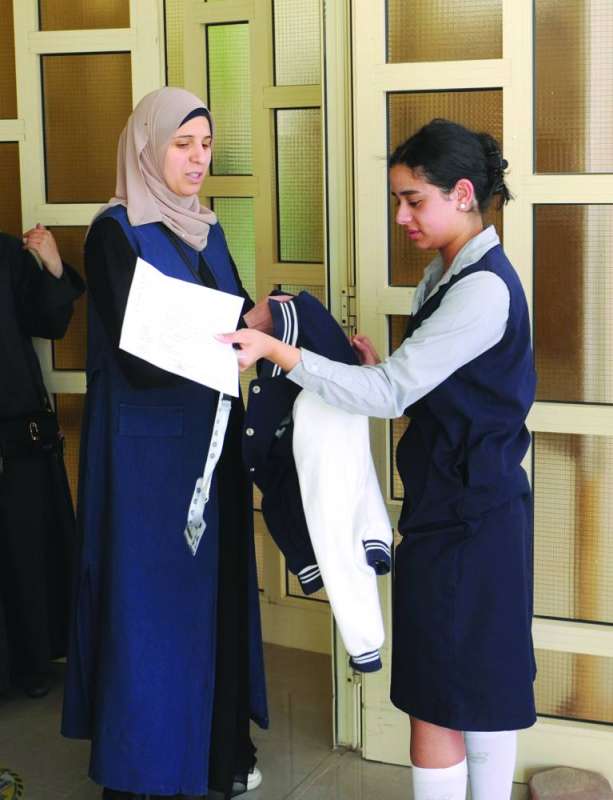 تفتيش إحدى الطالبات قبل دخولها قاعة الامتحان
