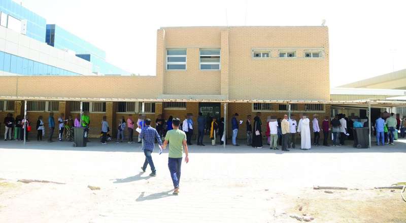 
العمالة المنتظرة لدورها تحتمي بمظلات السيارات هرباً من الشمس الحارقة	(تصوير سعود سالم)