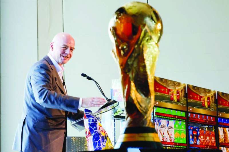 
جاني إنفانتينو متحدّثاً وأمامه كأس العالم 	 (رويترز)