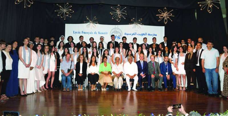 لقطة جماعية للخريجين والخريجات مع مسؤولي المدرسة	(تصوير سعود سالم)