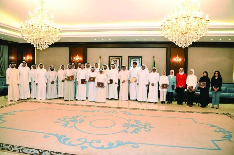 محافظ حولي متوسطاً أوائل الثانوية وأولياء أمورهم في لقطة جماعية
