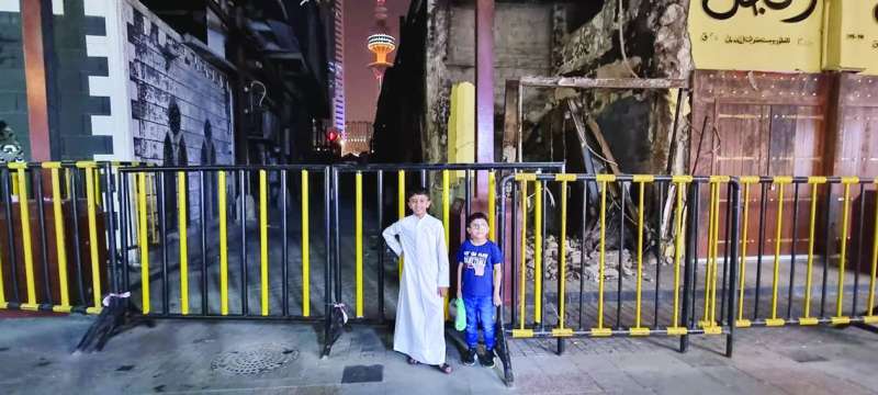 (مهمة) صغار يلتقطون صورة للذكرى خلف موقع الحريق 