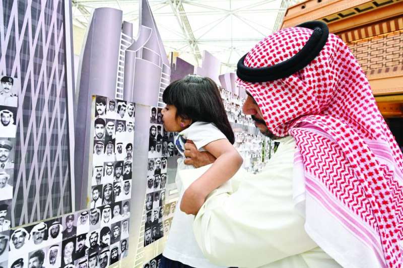 طفلة تقبل صورة أحد الشهداء الأبرار (تصوير أسعد عبدالله)