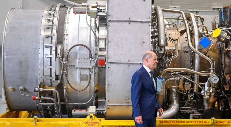 شولتس أمام التوربين الذي ترفض روسيا تسلمه لإعادة ضخ كميات الغاز السابقة عبر «نورد ستريم» خلال زيارته مصنع «سيمنز» أمس (ا ف ب)