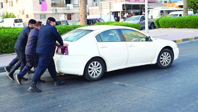 رجال الأمن يدفعون سيارة متهالكة لإزاحتها عن الطريق	(تصوير نايف العقلة)