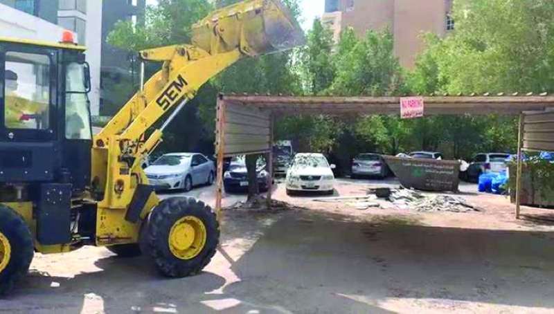 
جانب من إزالة مظلات السيارات المخالفة في منطقة الشعب