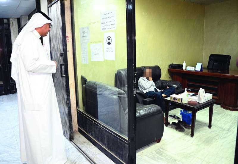 مبارك العازمي يتأكد من تفاصيل الترخيص التجاري لأحد المحلات (تصوير نايف العقلة)