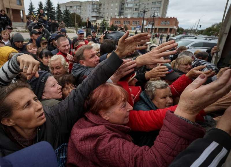أوكرانيون يتهافتون على المساعدات في بلدة بمنطقة خاركيف شرق البلاد (رويترز)