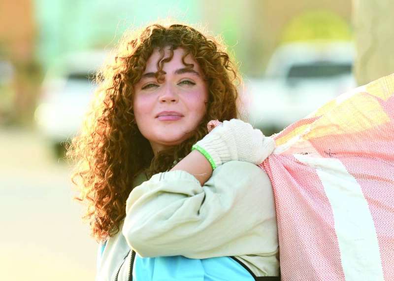 
متطوعة تحمل كيساً لجمع النفايات	 (تصوير أسعد عبدالله)
