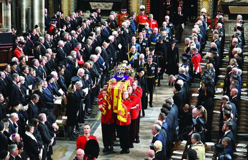 
أفراد العائلة المالكة وعدد من زعماء العالم يقفون احتراماً أثناء دخول نعش إليزابيث الثانية كنيسة ويستمنستر 	(رويترز)
