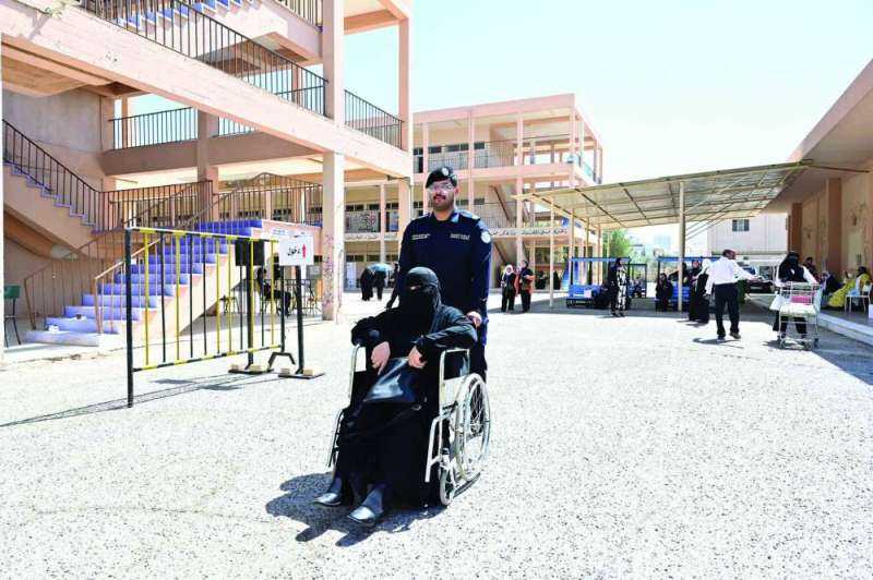 شرطي يساعد سيدة للوصول إلى مركز الاقتراع
