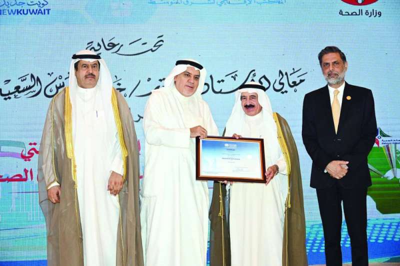 مختار ضاحية عبدالله السالم متسلماً شهادة اعتمادها مدينة صحية من الوزير السعيد