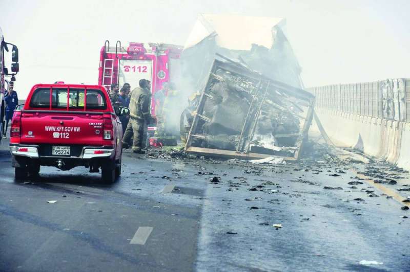 
إطفائيون إلى جانب الشاحنة المحترقة على «السادس» 	(تصوير أسعد عبدالله)
