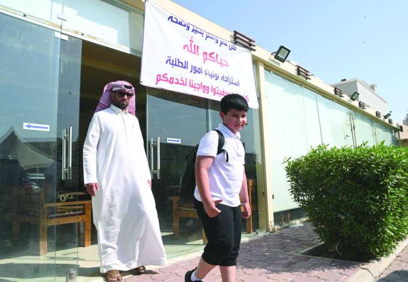 مواطن يخرج من الديوان بعد انصراف ابنه من المدرسة
