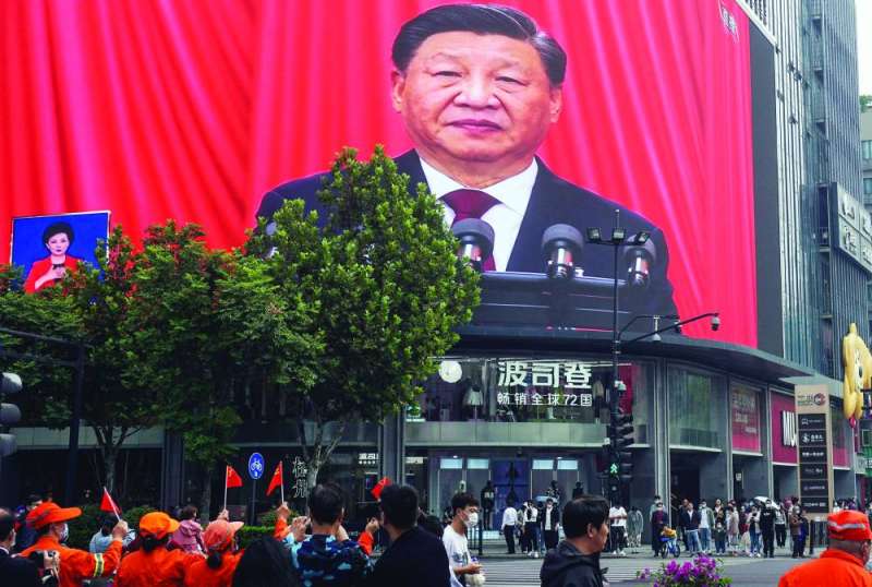 صينيون يشاهدون جينبينغ خلال افتتاح مؤتمر الحزب الشيوعي عبر شاشة كبيرة في إقليم تشجيانغ (أ ف ب)