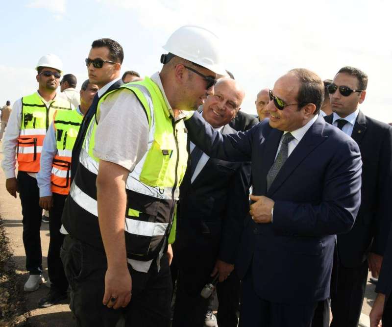  السيسي يتحدث مع أحد العملين في مصنع الرمال السوداء أمس