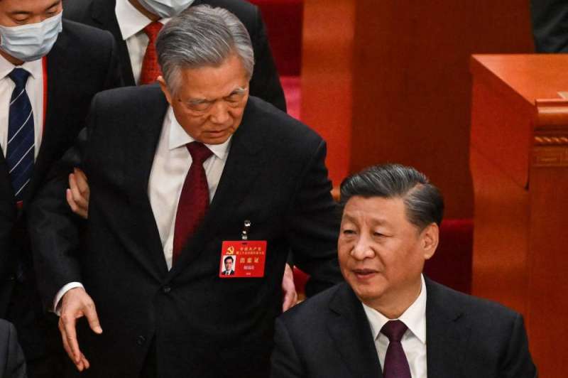 TOPSHOT - China's President Xi Jinping (R) talks to former president Hu Jintao as he is assisted to leave from the closing ceremony of the 20th Chinese Communist Party's Congress at the Great Hall of the People in Beijing on October 22, 2022. (Photo by Noel CELIS / AFP)