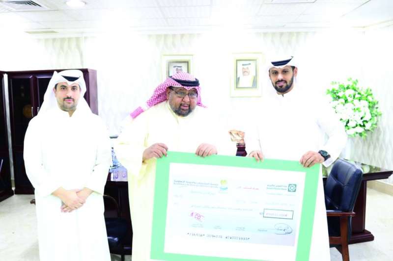 تسليم الشيك لمسؤولي بيت الزكاة
