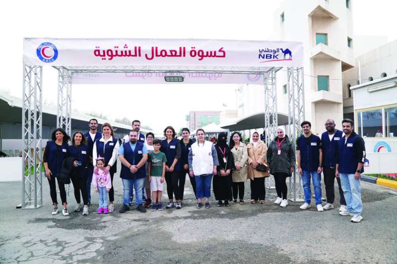 الشطي مع المتطوعين يوزعون الحقيبة الشتوية على العمال
