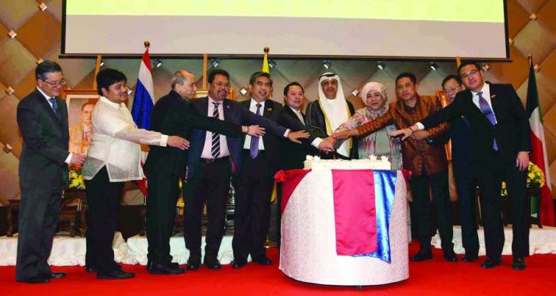السفير الحمد والقائم بالأعمال التايلندي وعدد من السفراء يشاركون بقص قالب حلوى الاحتفال (تصوير سعود سالم)