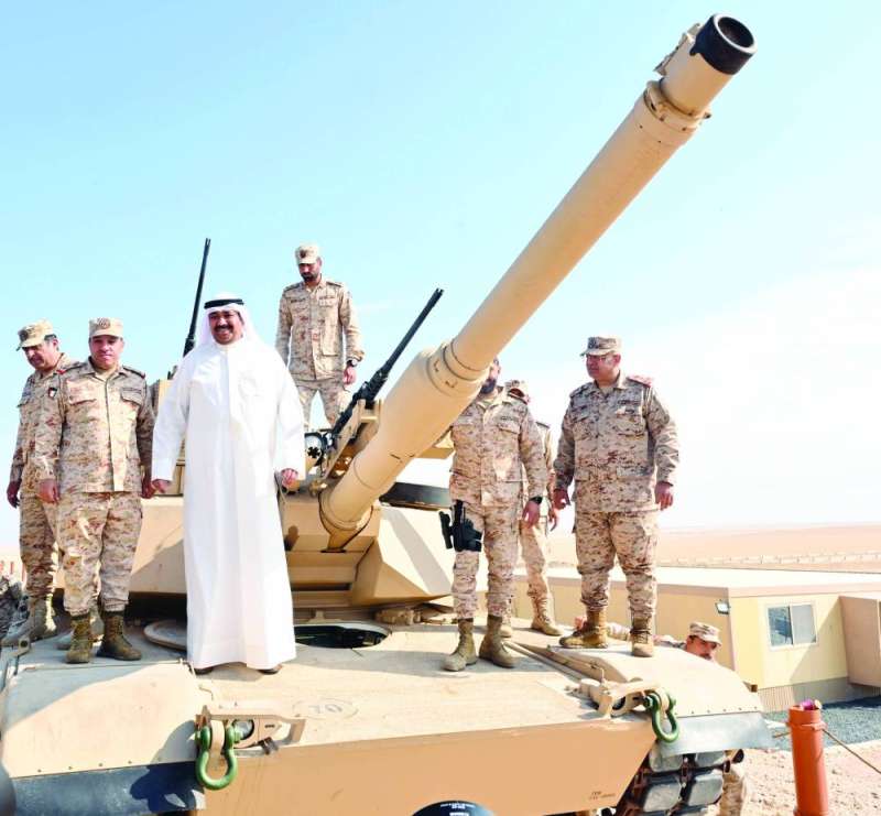 العلي على إحدى الدبابات مع بعض العسكريين
