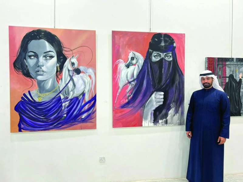 عمر الظفيري أمام لوحتيه