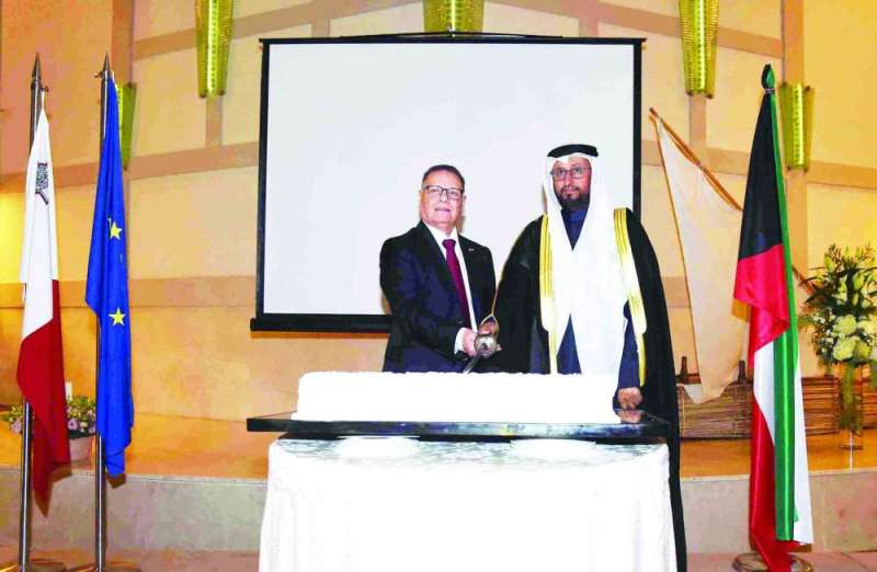 العجمي والسفير المالطي يتشاركان قص قالب حلوى الاحتفال 